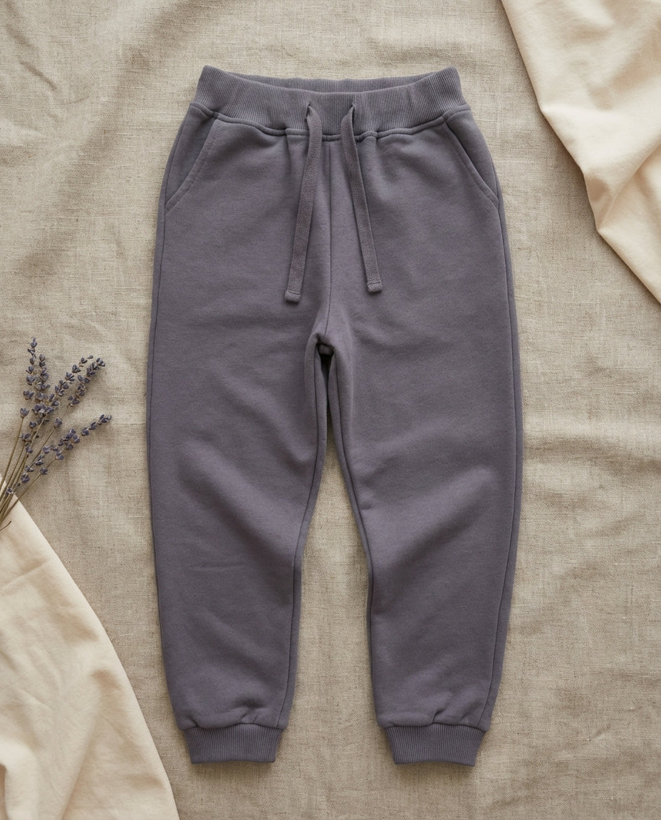 GOTS organik pamuk slate grey çocuk jogger pantolon linen zemin düz çekim, ribanalı bel ve paça detayı
