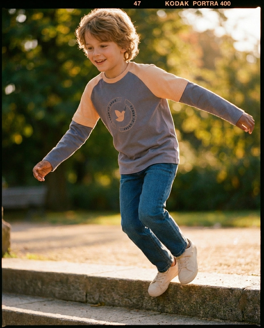 Organik pamuk raglan sweatshirt erkek çocuk açık hava lifestyle çekim, altın saat ışığı dinamik hareket karesi