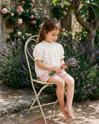 Patique fisto bluz pembe şort takım giyen kız çocuk anneanne bahçesinde lavanta demetiyle vintage sandalye sahnesi