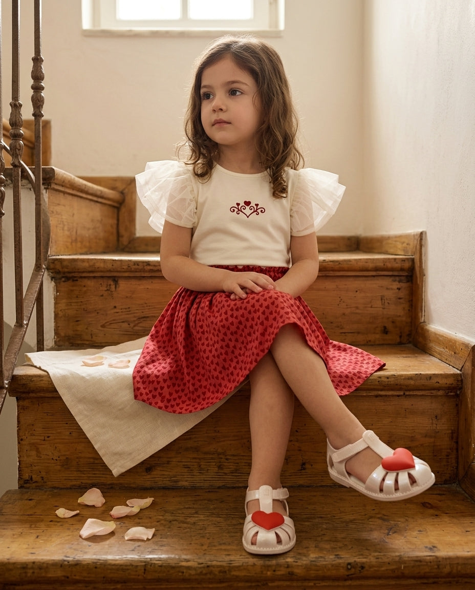 Patique kalp etek nakışlı tişört takım Mini Melissa krem kalp sandalet giyen kız çocuk vintage ahşap merdivende