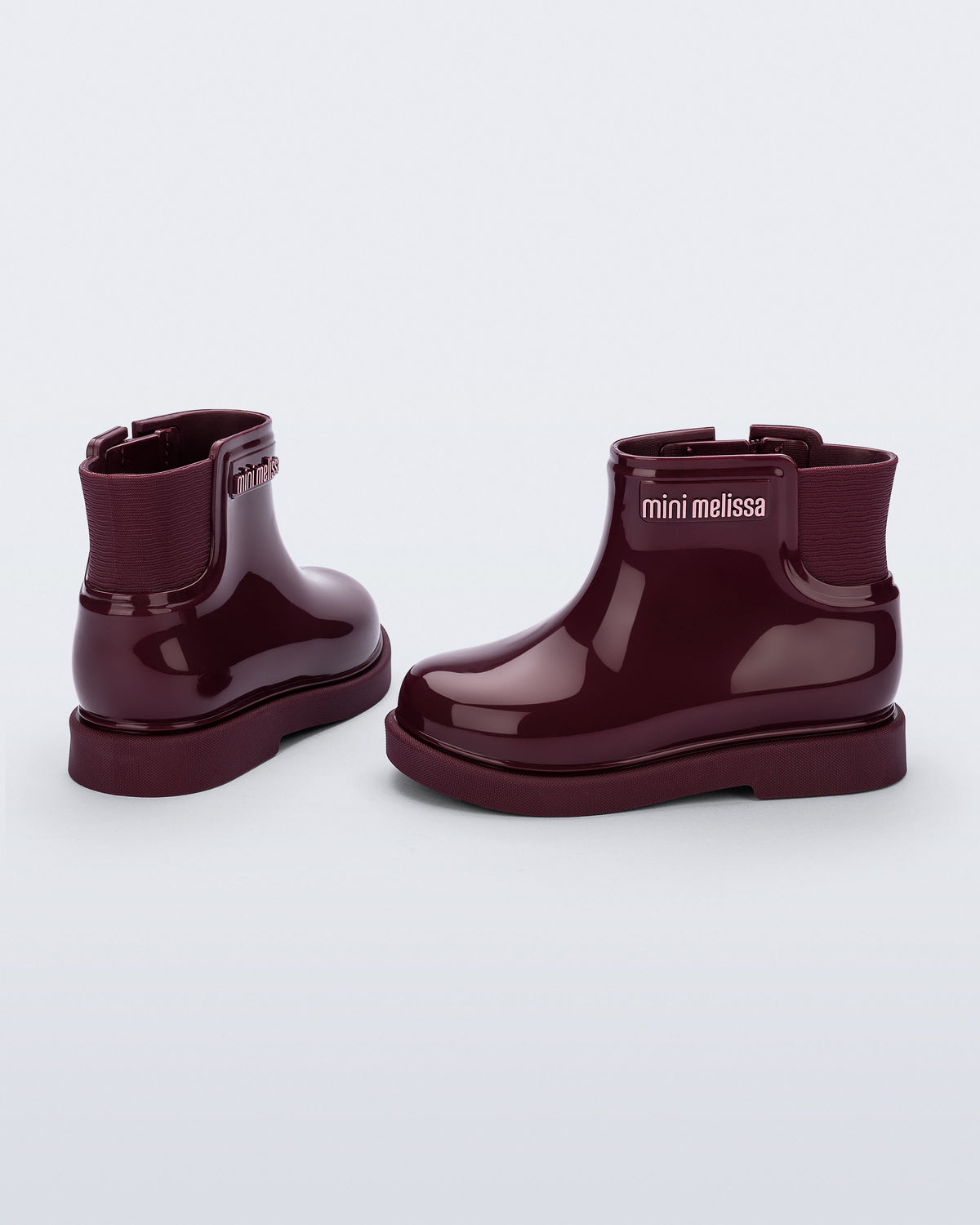 Mini Melissa bordo rugan bot çifti, açılı arkadan görünüm; dokulu elastik körüğü, kabartma logosu ve kalın tabanı.